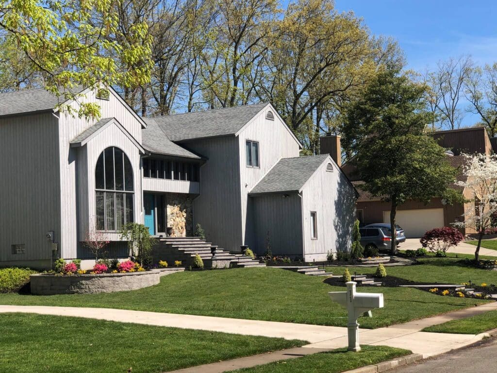gray house, lawn, white mailbox